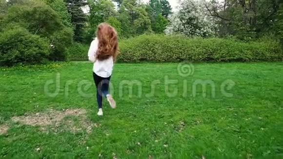长卷发的欧洲女孩带着肥皂泡在公园里奔跑很长的头发随风飘动慢慢地视频的预览图