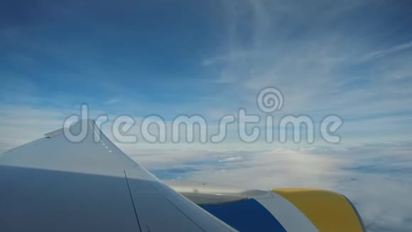 飞机视图窗口概念窗外的飞机可以看到引擎和机翼在云和天空蓝色或蔚蓝的天空在陆地上视频的预览图