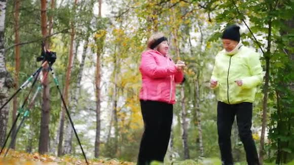 成熟的女人在秋天的公园里做体操和说话视频的预览图