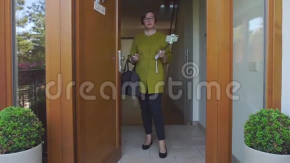 一个穿绿色外套的女人站在门口视频的预览图