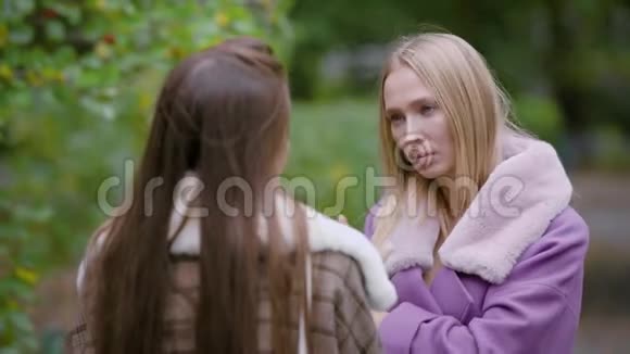 两个穿暖和外套的时髦女人在交谈视频的预览图