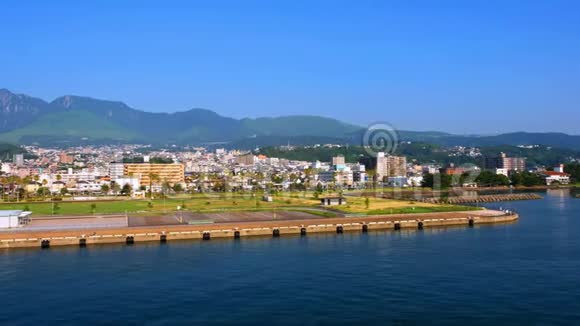 阳光明媚的一天在一个度假的小镇北浦日本可以看到山脉视频的预览图