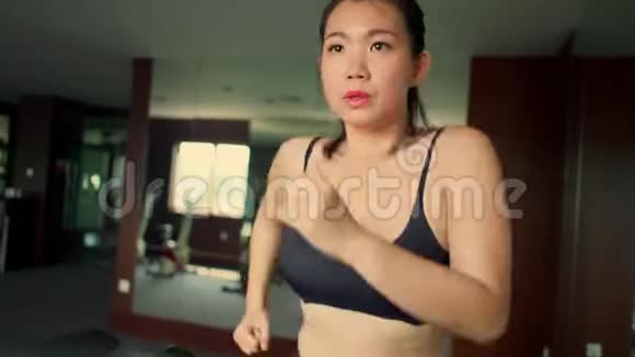 年轻有魅力可爱的亚洲女性在酒店健身房或健身俱乐部跑步锻炼在跑步机上艰苦训练视频的预览图