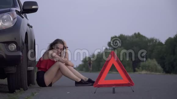 女青年坐在断车附近女青年伤心女青年用手机打电话闹事视频的预览图
