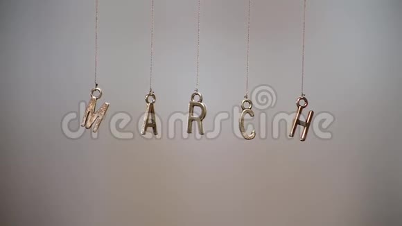 三月用金属字母做成的挂在背景模糊的绳子上视频的预览图
