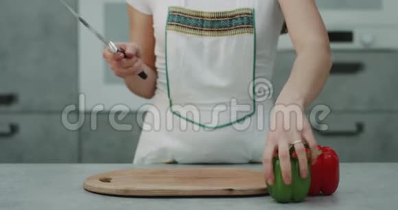 捕捉视频慢动作的女人用一把大刀切了两个甜椒红和绿现代厨房视频的预览图