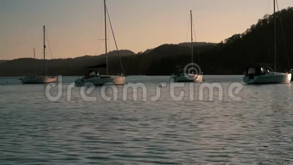 英国坎布里亚日落时帆船坐在平静的温德米尔湖上视频的预览图