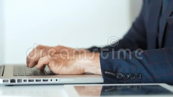 在白色办公室用笔记本电脑打字的商人特写视频的预览图
