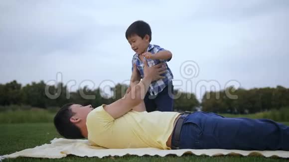 可爱的亚洲父亲举起他的笑男孩视频的预览图