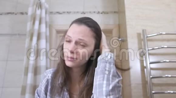 盥洗室里一个疲惫的女人打着自己的脸颊醒来视频的预览图