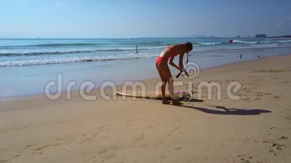 女人把冲浪板绳绑在腿上以抵御图片海景视频的预览图
