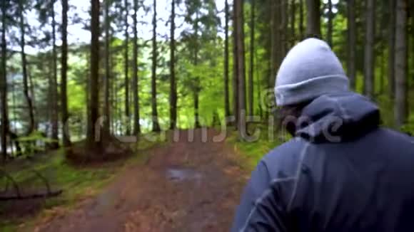 在大自然中行走的人行走在山林深处戴帽子的男孩在树林里散步关节头部跟踪射击徒步旅行者视频的预览图