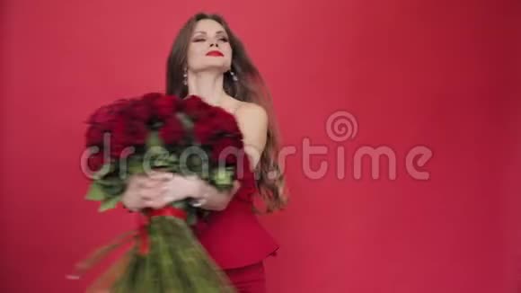 穿着红裙子手捧玫瑰的漂亮女人视频的预览图