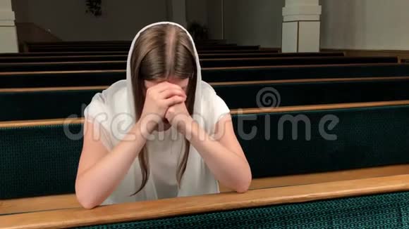 在浸信会教堂祈祷的年轻虔诚的妇女欧洲大教堂虔诚的天主教徒圣地内部视频的预览图