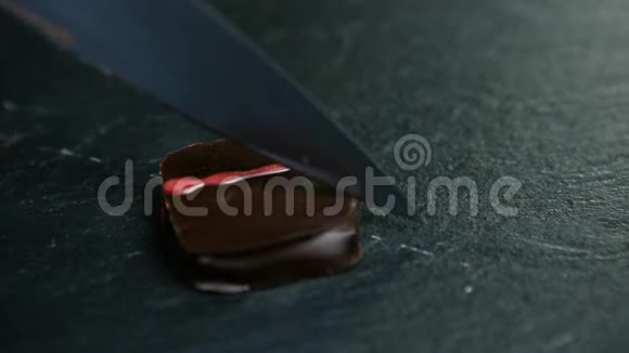 用菜刀将方形巧克力糖果切成两半视频的预览图