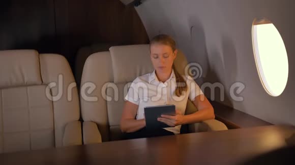 有平板电脑在商务喷气机里面的女商人视频的预览图