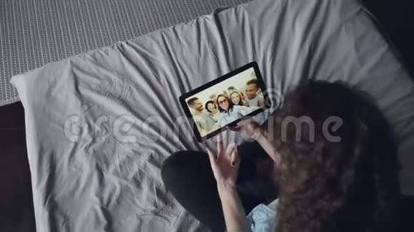 高角度拍摄女性手持平板电脑与朋友在线交谈制作视频电话青年群体视频的预览图