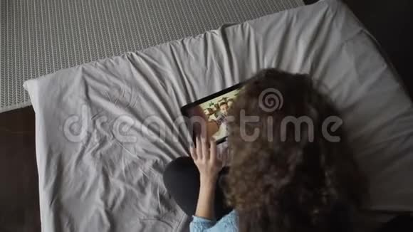 高角度拍摄女孩制作视频电话使用平板电脑和与朋友在线讨论新闻年轻女子视频的预览图