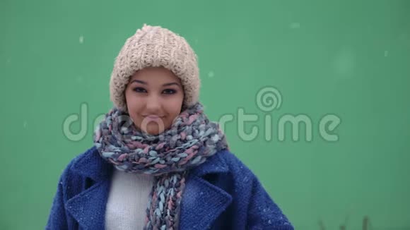一个微笑的女人在冬天的背景下竖起大拇指的肖像冬季概念雪和女人视频的预览图