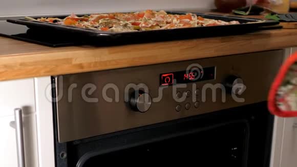 慢条斯理的女人把烤盘和披萨放进烤箱视频的预览图