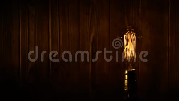 老式爱迪生灯泡在木板背景上发光视频的预览图