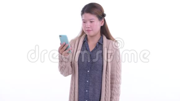 快乐的年轻亚洲女人用电话准备过冬视频的预览图