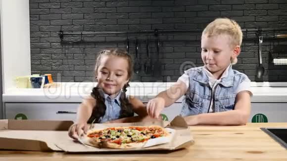 垃圾食品孩子们最喜欢的食物两个孩子在吃披萨试着吃第一块生活方式概念4公里视频的预览图