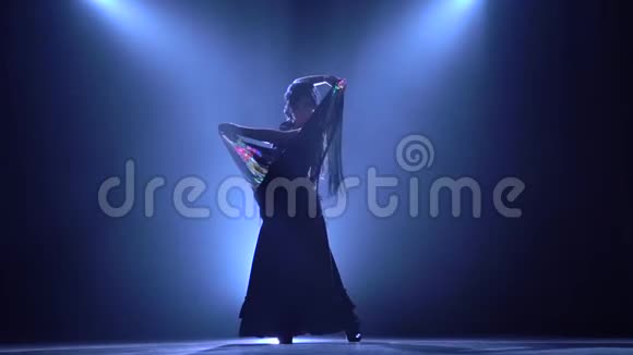 跳舞的女人手里拿着一个西班牙燃烧舞的咒语从后面发光烟雾背景视频的预览图