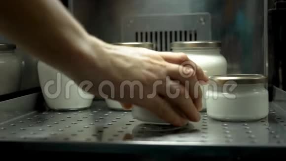 手把装有牛奶的罐子放进冷库视频的预览图