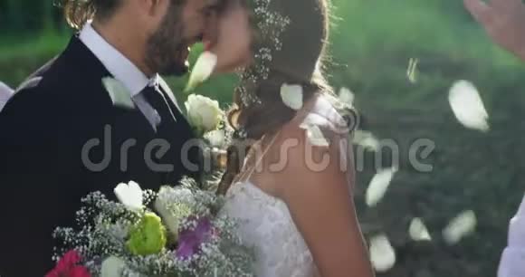 新娘和新郎接吻背景客人投掷花瓣4K4k视频的预览图