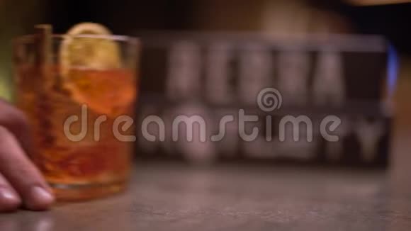 男人的手用一块橘子和肉桂在桌子上的酒精射击视频的预览图