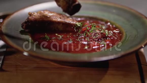 未识别的厨师把猪肉肋骨放入盘子与美味的红色罗宋汤快关门视频的预览图