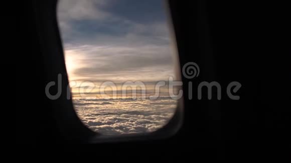 透过飞机的舷窗透过云层俯瞰早晨的天空视频的预览图
