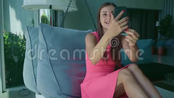 年轻女孩在Skype上打电话下午躺在挂床上动作缓慢视频的预览图