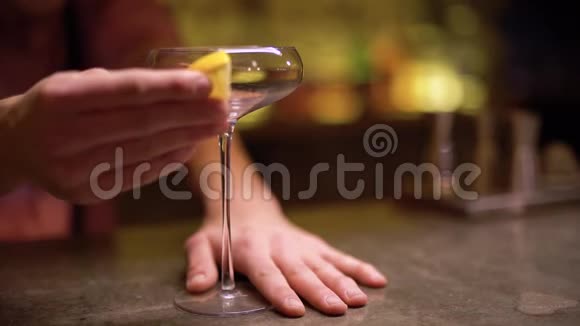 在现代咖啡馆里男人用一片橙色擦着高高的玻璃杯视频的预览图