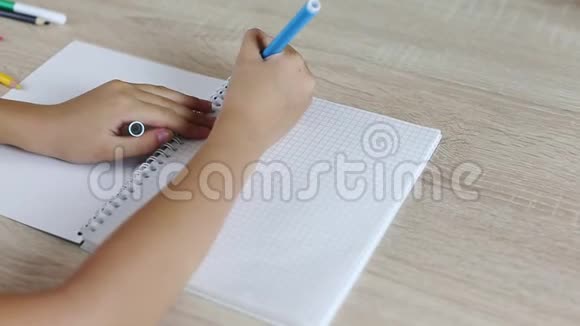 小女孩用纸笔记本写回学校的信坐在桌子旁的年轻女孩白人女孩写信视频的预览图