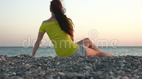 日落时在石滩上的女孩视频的预览图