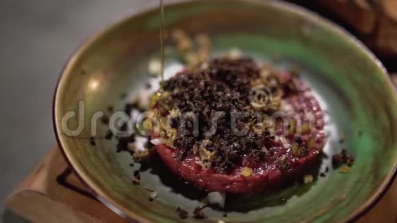 餐盘上的鞑靼在餐厅厨房里供应橄榄油倒在食物上视频的预览图