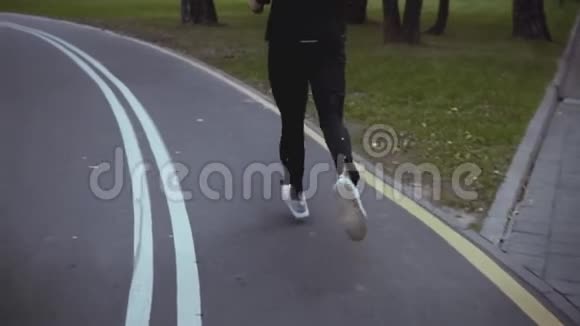 人奔跑在秋公园路上转弯后景慢动作运动员在宁静的小巷里慢跑生活节奏视频的预览图