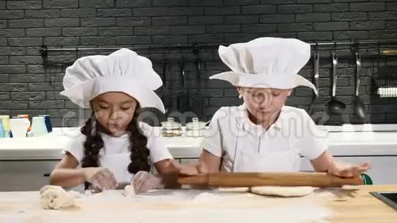 厨师小子两个孩子玩厨房穿着厨师帽和围裙的小男孩和学龄前男孩为生日做蛋糕视频的预览图