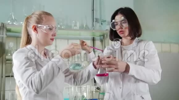 化学实验室两名年轻的实验室技术人员正在进行液体实验视频的预览图
