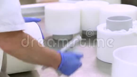 乳品厂工人奶酪制作工艺将奶酪豆腐放入塑料模具视频的预览图