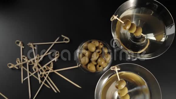 豪华马提尼黑桌上装饰着橄榄木条和两杯马提尼里面有橄榄视频的预览图