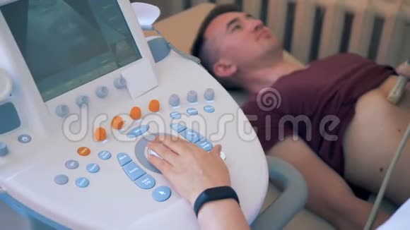 医生扫描病人胃一名医生在一家诊所对一名男性病人进行超声检查视频的预览图