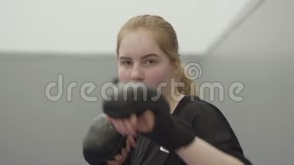 年轻的金发女孩戴着拳击手套在镜头前翻脸视频的预览图