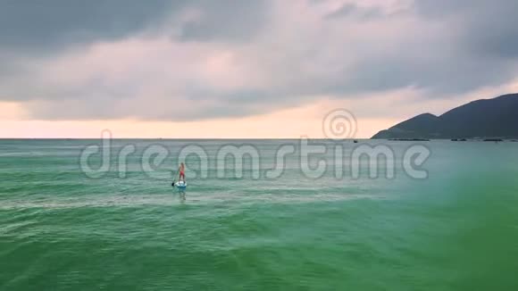 船帆上的孤独苗条的女士驶向地平线上的岛屿视频的预览图