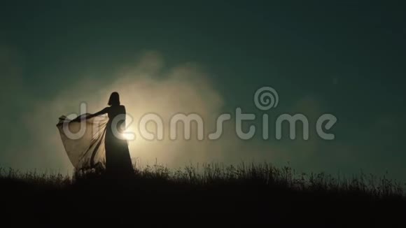 日落时的女孩在田野里散步慢动作剪影视频的预览图