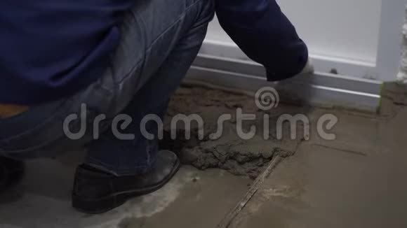 公寓和房屋的修缮建筑工人把水泥洒在地板上并整平视频的预览图