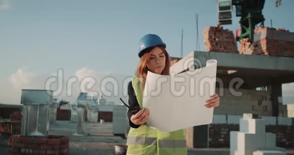 集中年轻的工程师妇女从大张旗鼓地穿着安全设备分析施工计划视频的预览图
