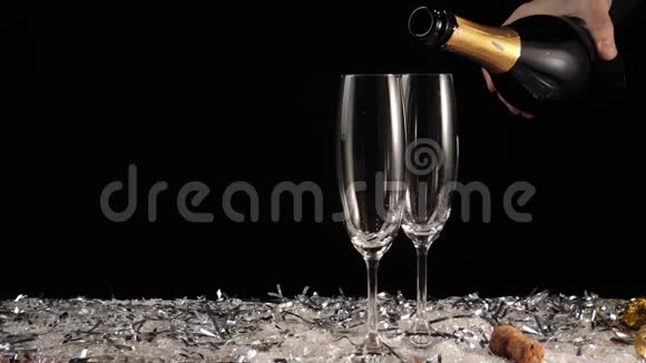 好香槟酒两个空杯子从香槟酒在白色的雪和黑色的背景配有起泡葡萄酒的长笛手中的水视频的预览图